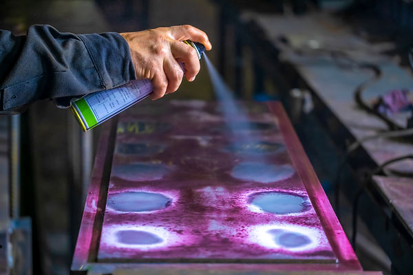 Spraying liquid penetrant to detect defects in welds