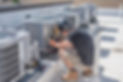 View of a technician repairing a commercial HVAC system