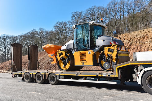 Un camion transporte une machine de construction