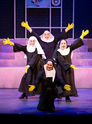 Four nuns wearing rubber gloves and posing