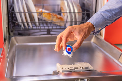 Geschirrspüler, Hand legt Tap in die Maschine