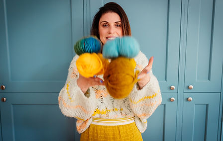 Debbie holding colorful balls of yarn for a knitting project at Make Space in Chelmsford