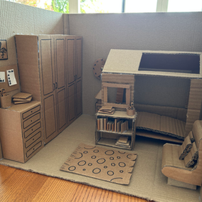 Cardboard model of a craft bedroom with desk and bunk bed