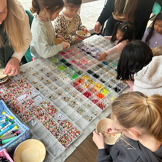 Children choosing colorful beads during a craft event.