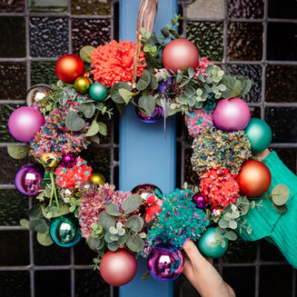 Colorful Christmas wreath with pink and orange ornaments