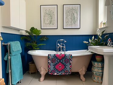 Clawfoot tub in a bathroom with blue wood paneling at the Make space location home in chelmsford