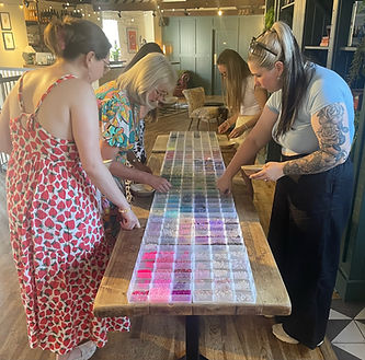 Women choosing colorful beads at a Make space craft party workshop.