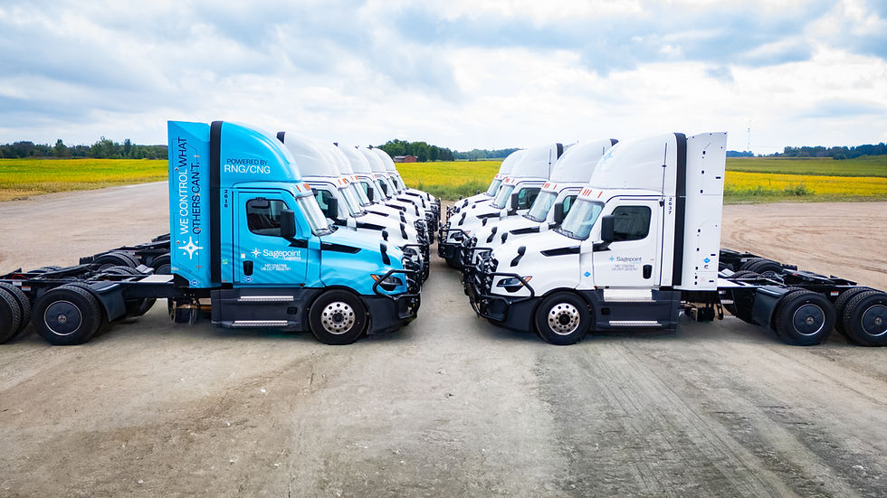 Blue and white Sagepoint Logistics CNG trucks parked in two rows facing each other at the terminal.