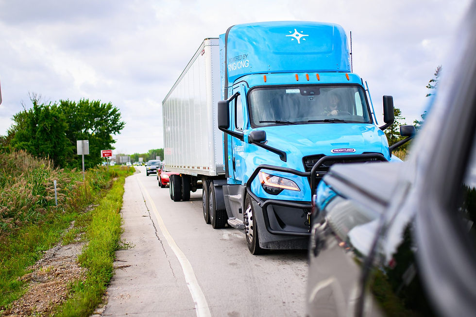 Blue Sagepoint Logistics Freightliner powered by RNG/CNG hauling a trailer down a two-lane road.