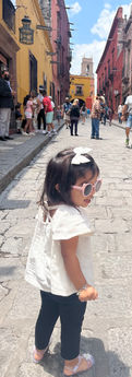 Photo of a child exploring the cobblestone streets and colorful scenes of San Miguel de Allende, with a sense of wonder and excitement