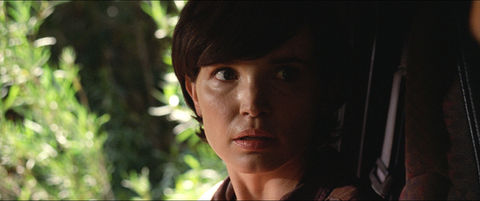 The woman in the passenger seat of the car looks at her driver in resolute terror.