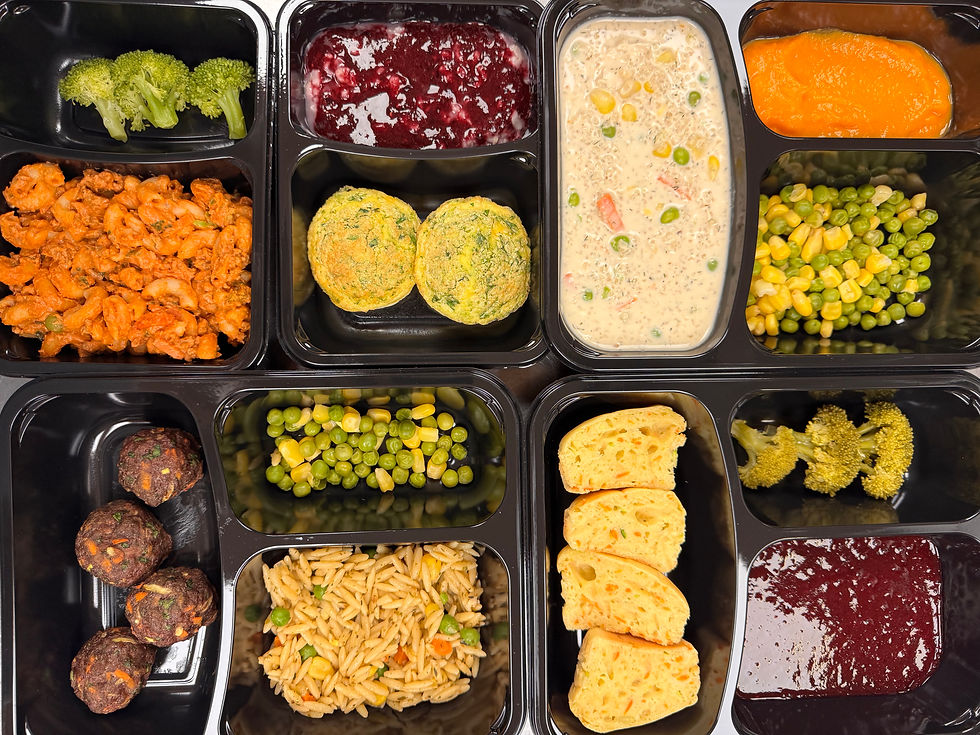 Eye-level view of a colorful baby meal tray with fresh vegetables and grains
