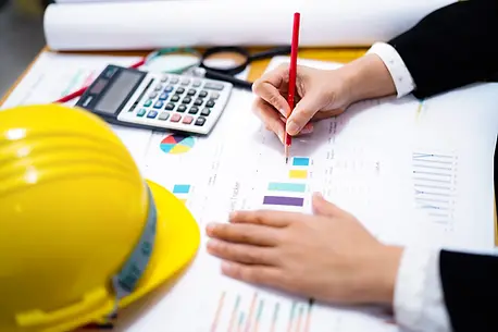 Professional reviewing construction estimation documents with hard hat