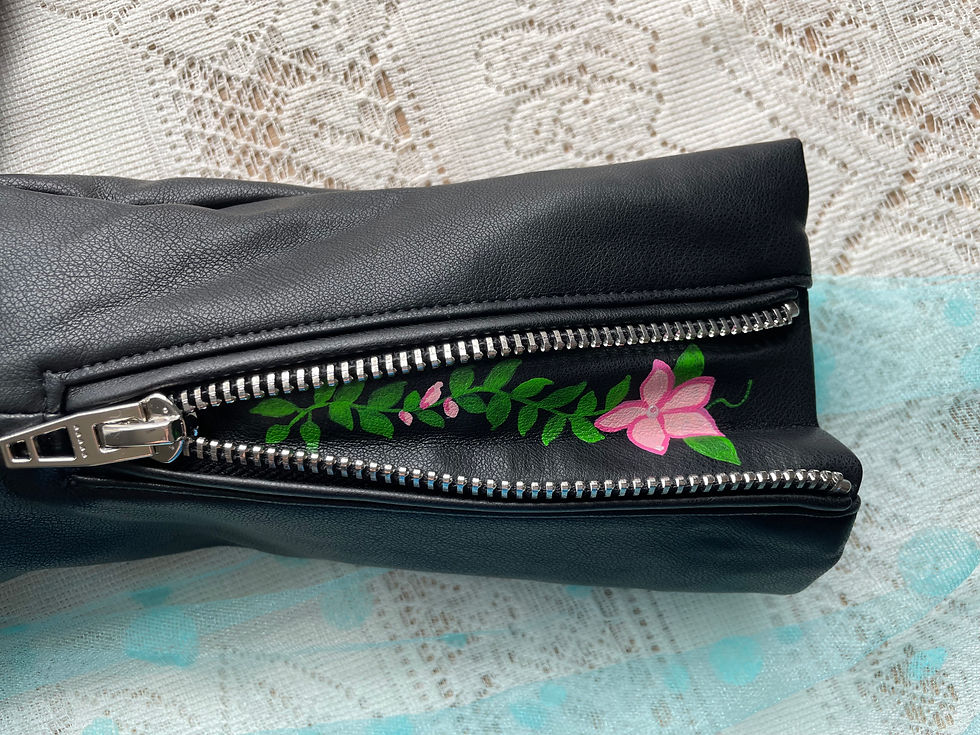 Thumbnail: Black leather clutch with floral detail and silver zipper; sixteensisters.com