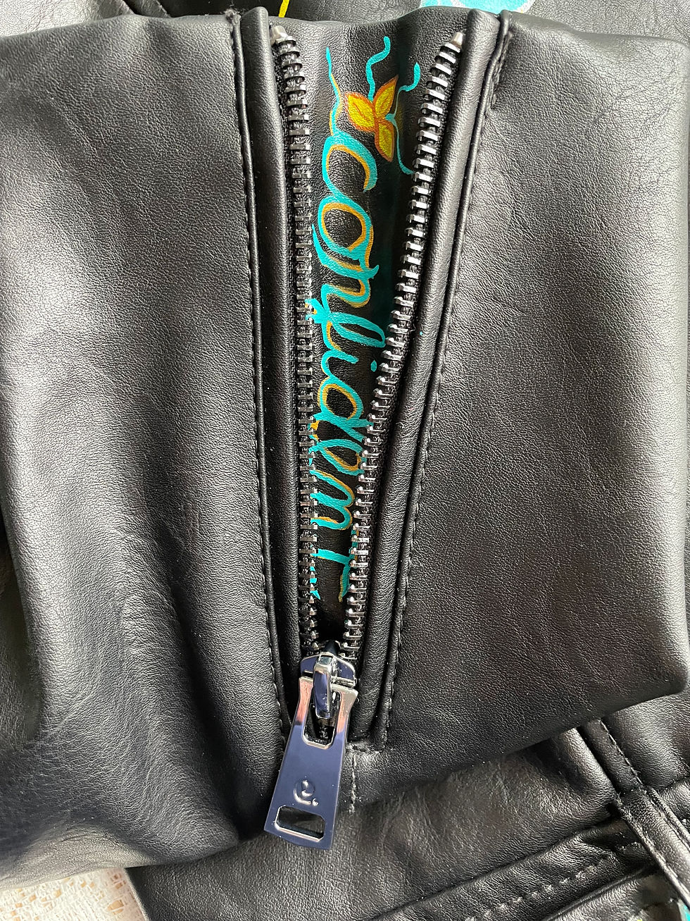 Thumbnail: Close-up of black leather jacket with visible text: confidant