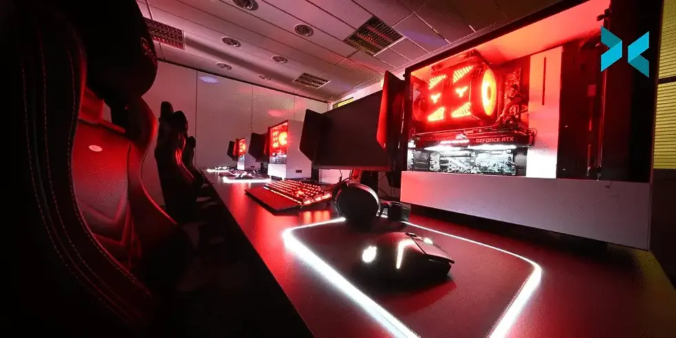 Stations de jeu alignées, éclairage rouge vif. Ordinateurs puissants, ambiance compétitive, décoration moderne avec sièges gaming noirs.