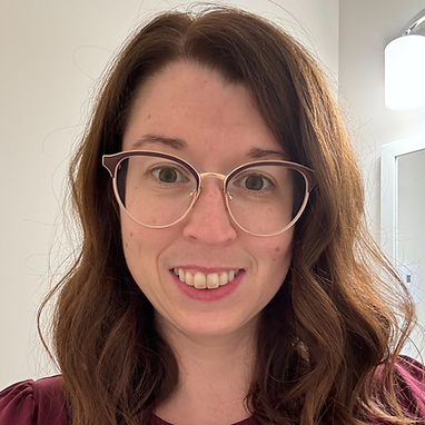 Female Board of Directors member with glasses and wavy brown hair.