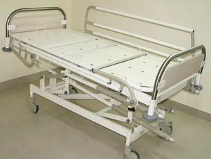 Low-height hospital bed with side rails in pediatric ICU setting