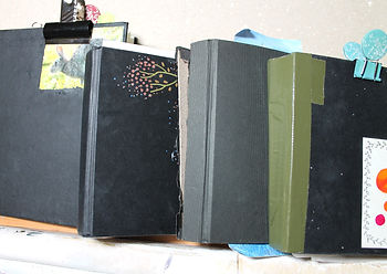 Some of my sketchbooks. I always draw or stick something on the front.