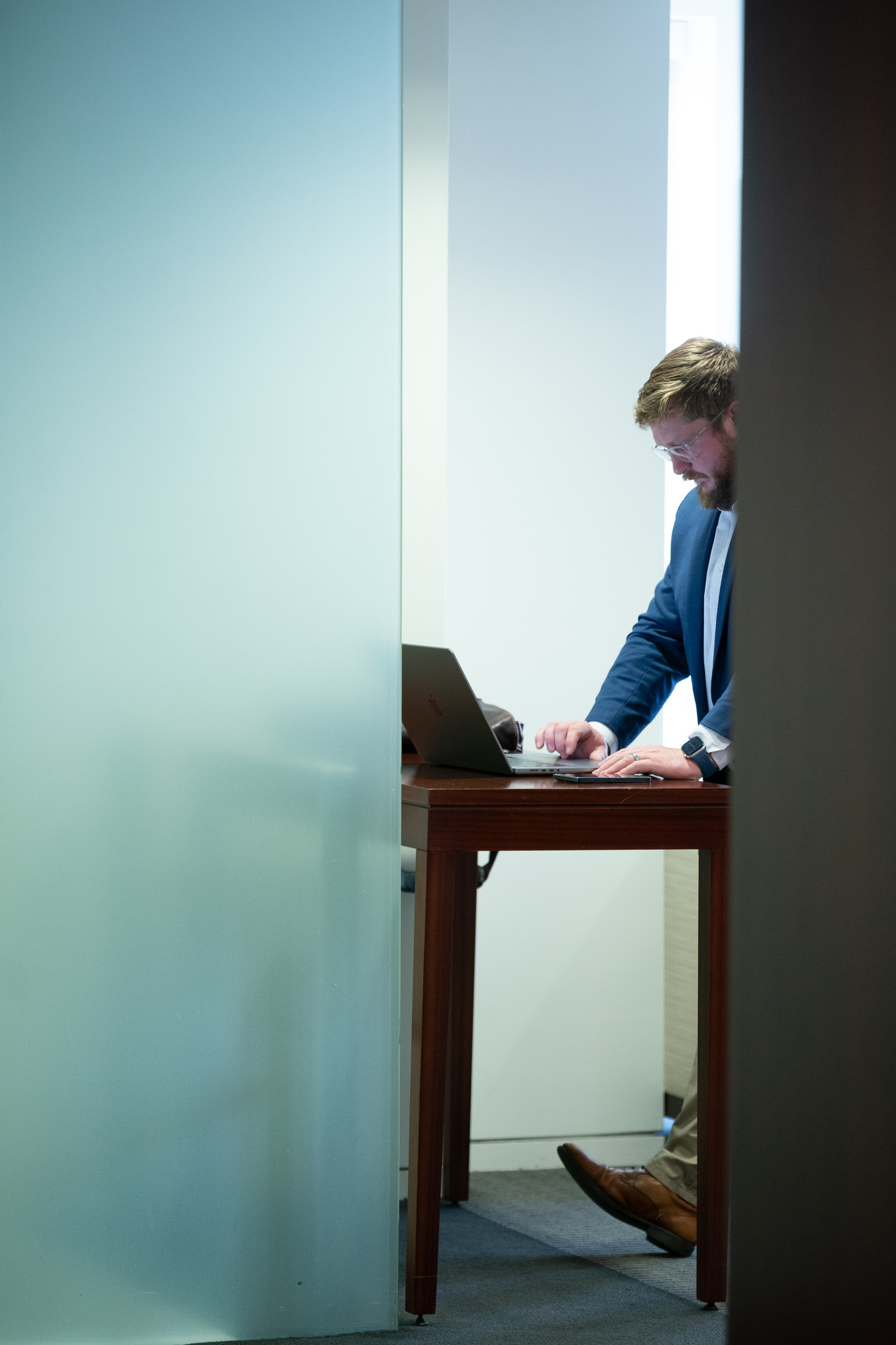 Professional working behind translucent glass in a modern office