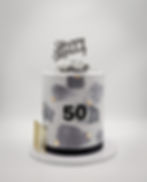 Grey and white 50th birthday cake with hand-painted brushstrokes, gold leaf and a vintage car topper