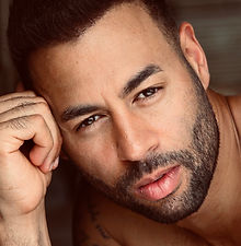 Daniel - headshot of male model with short dark hair, a well-groomed beard, leaning on his hand, represented by ROC Talent Agency UK