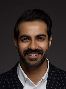 Zain H - headshot of male model with a swept back hair, a well-groomed beard, and wearing a blazer over a white shirt, represented by ROC Talent Agency UK