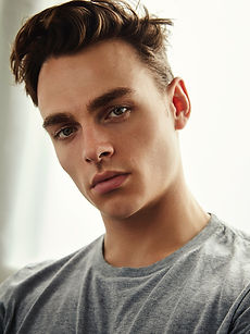 Oliver W - headshot of male model with dark hair, strong brows, and wearing a grey T-shirt, represented by ROC Talent Agency UK