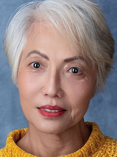 Lynda L - A headshot of a classic model with short hair, a natural expression and wearing a yellow jumper represented by Roc Talent agency UK