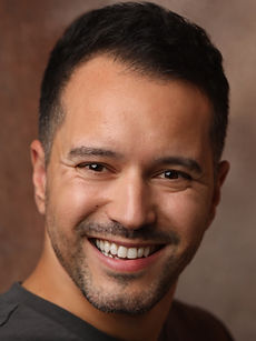 Brandon - A headshot of a real model with brown styled hair, light stubble, and a bright smile, represented by Roc Talent Agency UK