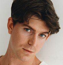 Matthew H - headshot of a male model with a textured hairstyle, a clean-shaved face, and wearing a white top, represented by ROC Talent Agency UK