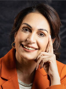 Jabeen - A headshot of a classic model with tied back hair, a natural smile and wearing a orange blazer represented by Roc Talent agency UK