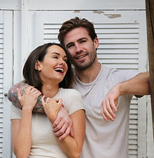 Rose and Guy - shot of a couple featuring a woman with a short bob and a wide smile, and a man, he has his arm wrapped around her, swept-back hair and a natural smile, represented by ROC Talent Agency UK