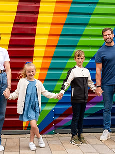 The Campbell Family - a family modelling shot with two parents with happy expressions surrounded by their two children, their daughter with styled blonde hair, their son with short blonde hair, all together outside, represented by ROC Talent Agency UK