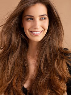 Georgia D - headshot of a female model with brown curly hair, a natural smile, and wearing a silver top, represented by ROC Talent Agency UK