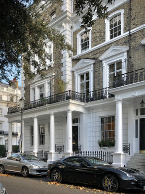 Townhouses encircling a large garden square.