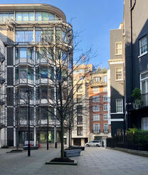 Trees in a quiet, private square, surrounded by offices and townhouses.