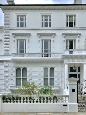 Large, white, semi detached townhouse.