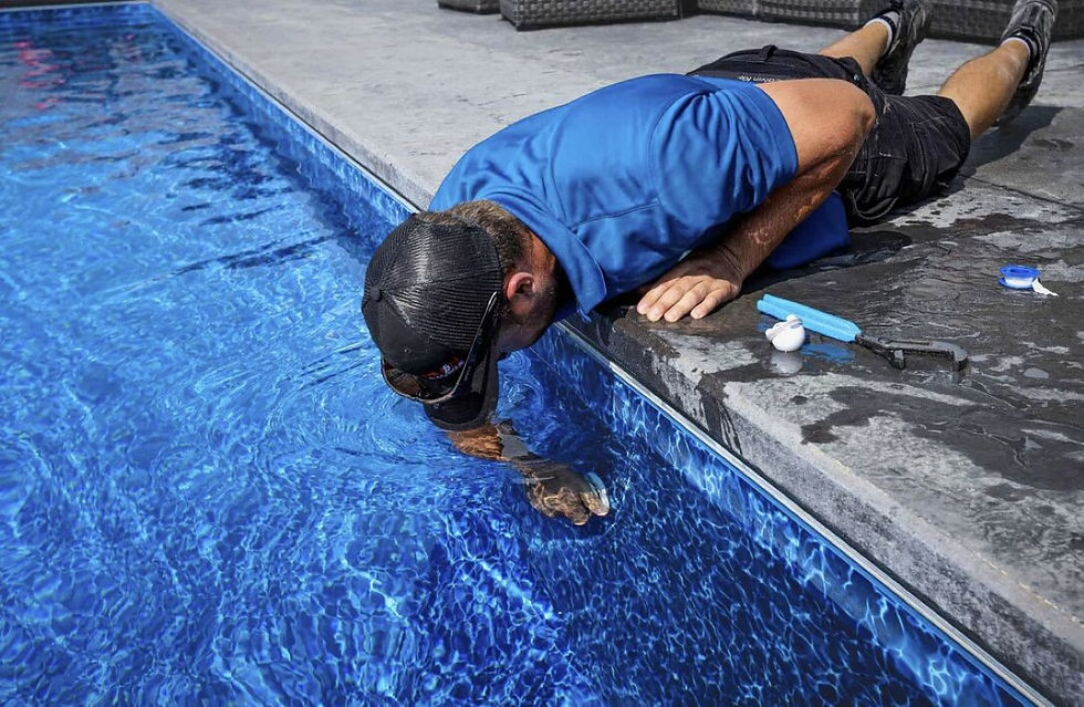 Pool technician performing weekly service on a backyard pool in The Woodlands TX