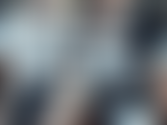 Femdom-Schulmädchen-Cover: Blonde Little Lina (172 cm, Zöpfe mit rosa Schleifen, Nerd-Brille, weiße Bluse, winziger Karo-Rock, reine weiße Overknees, weiße Converse) sitzt selbstbewusst auf dem Lehrerpult, Beine leicht gespreizt. Muskulöser KinkyChrisX (Tattoo, Choker, Brille) sitzt davor und schaut devot hoch. Klassenzimmer, dramatische Beleuchtung, voller Power-Exchange-Vibe.