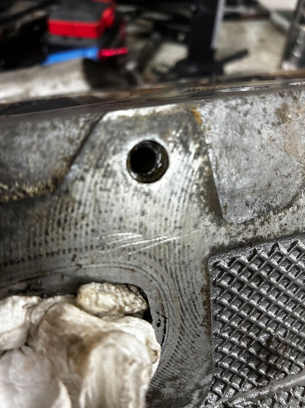 Close-up view of a broken exhaust bolt stuck in an engine cylinder head