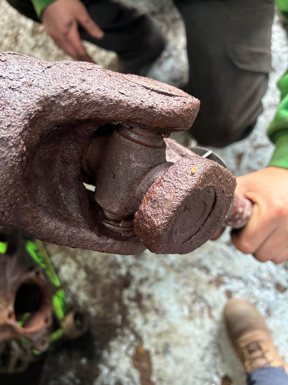 Close-up view of a vehicle driveshaft with worn u-joints