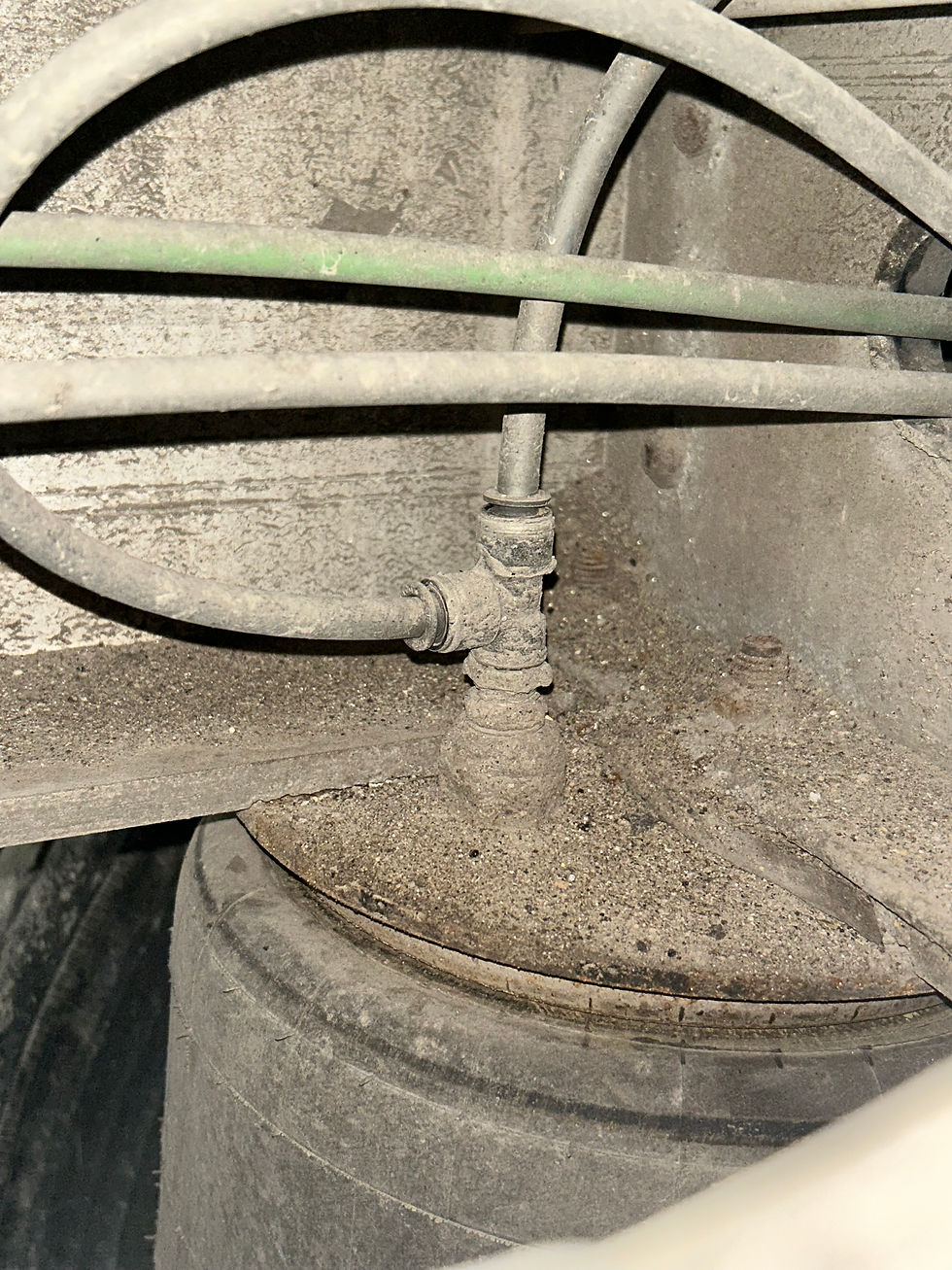 High angle view of a mechanic inspecting air brake hoses and fittings on a tractor trailer
