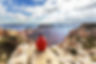 Person in red jacket overlooking Grand Canyon