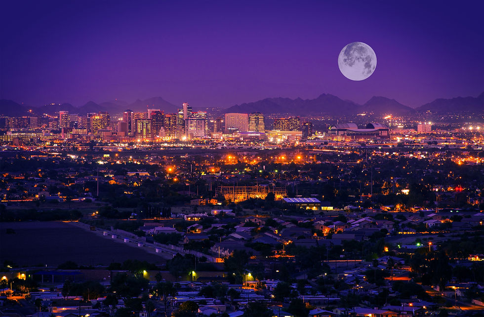 Nighttime view of Phoenix, Arizona, illuminated city skyline under a full moon