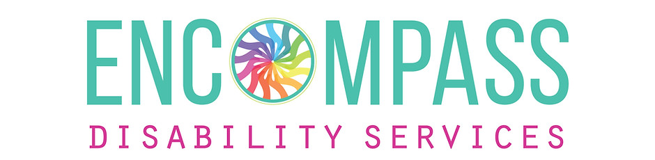 Boy in wheelchair smiling, with support worker holding his hand.