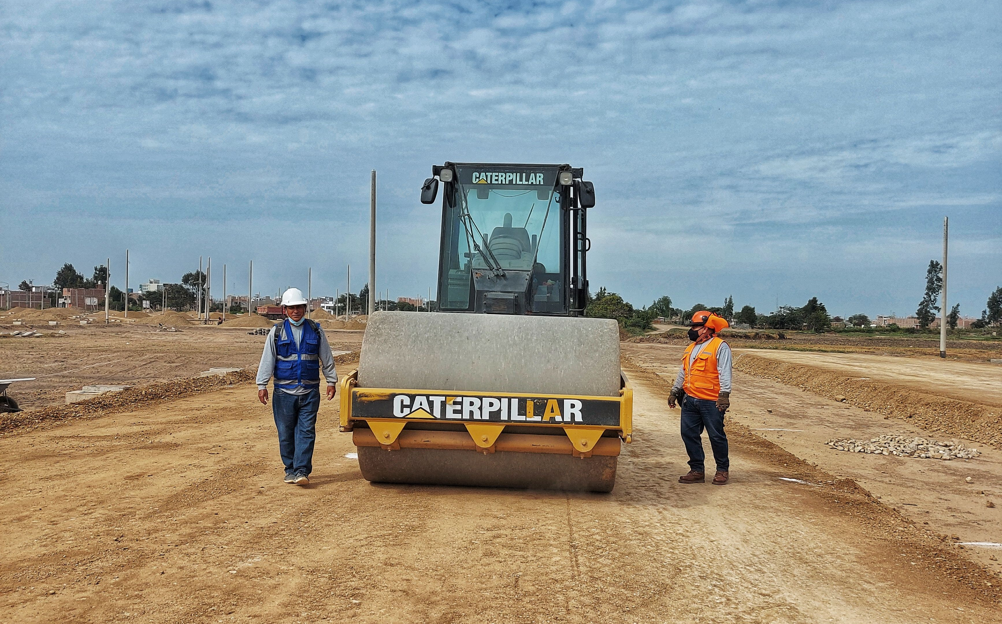 Subdivisión de chacras: apertura de calles internas con rodillo compactador y operarios en un loteo rural