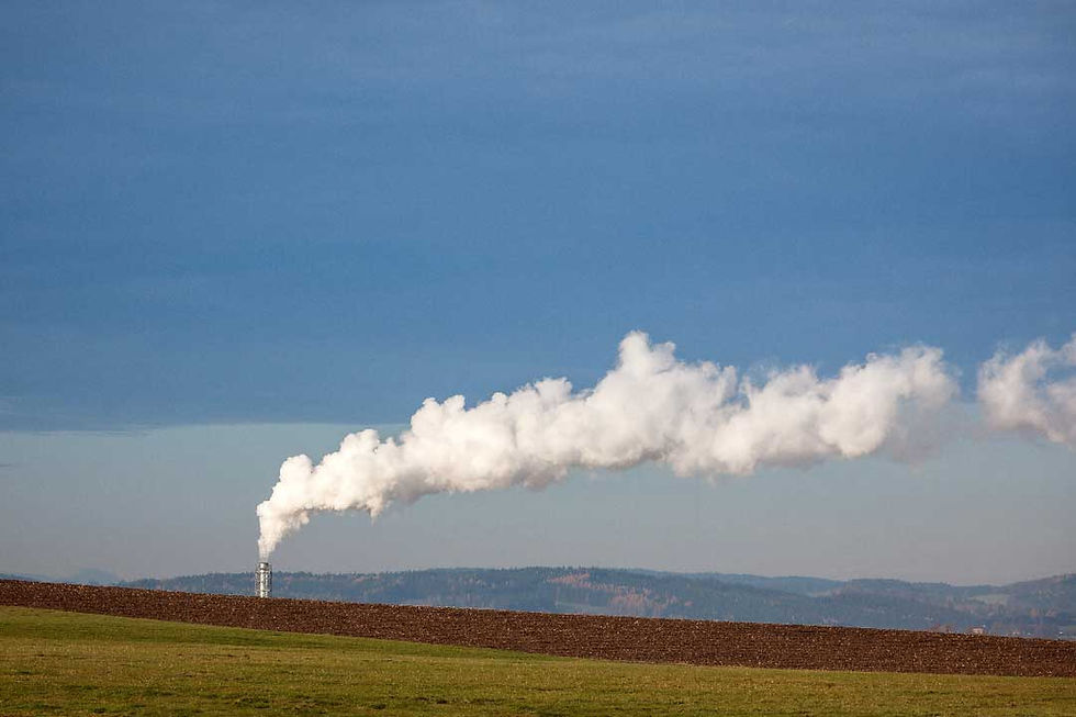 Steam plume rising from a power plant in a rural landscape