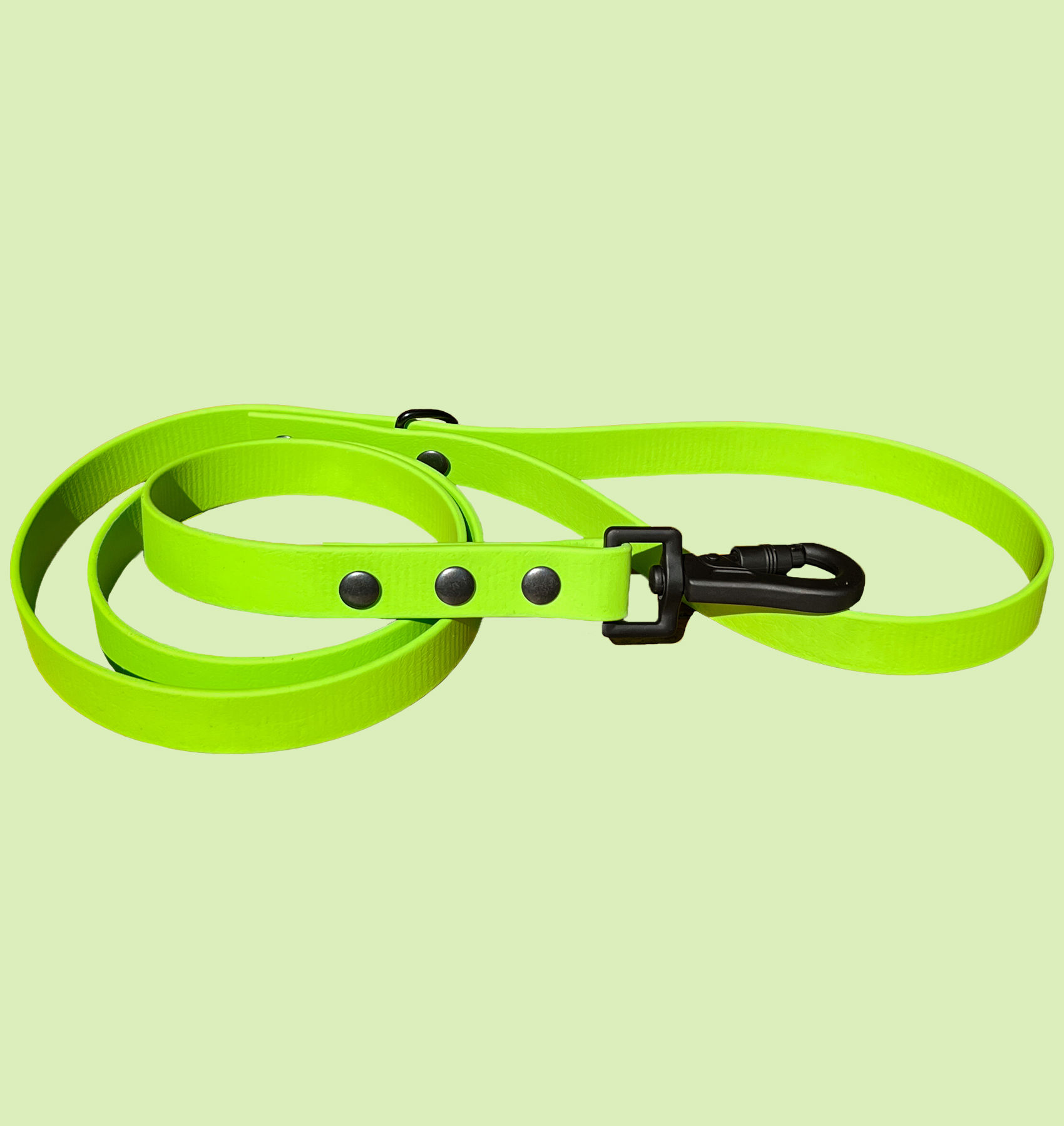 Bright green Apple BioThane® leash coiled neatly on green background.