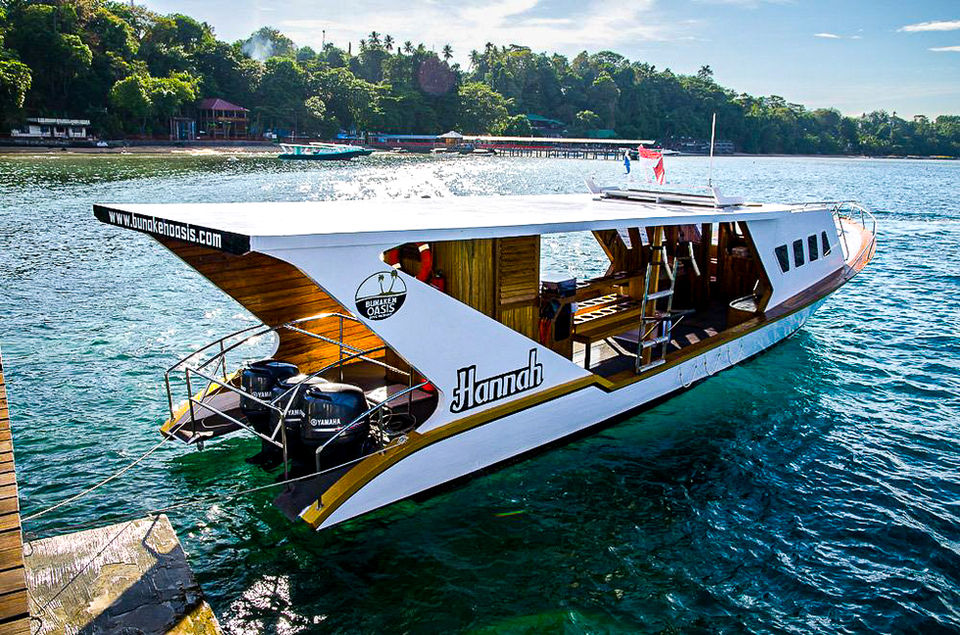 Hannah boat docked at the pier, blue ocean, sunny day, ready for adventure.
